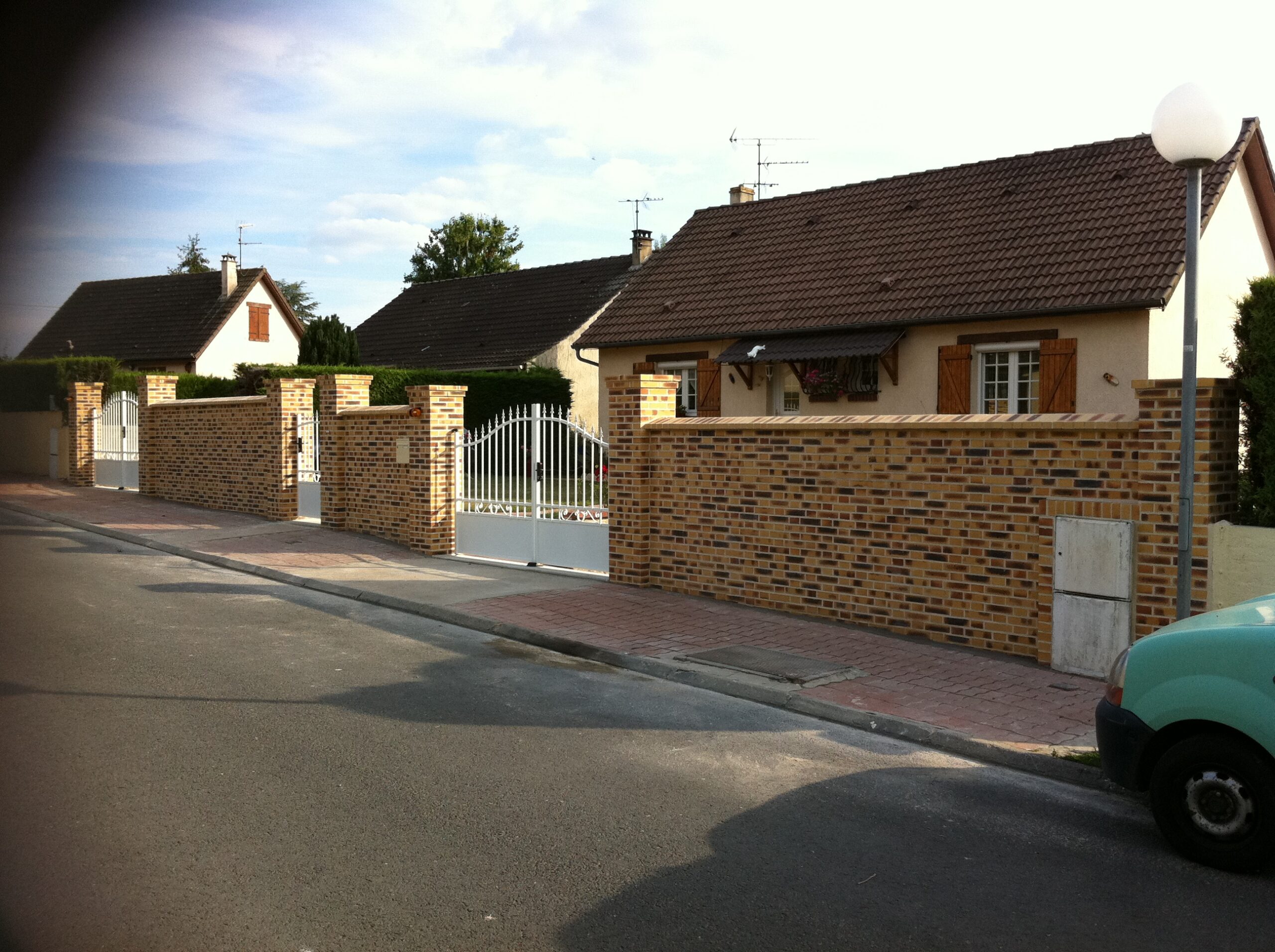 Mur de clôture en briques pleines décorative maçonnées à la chaux.